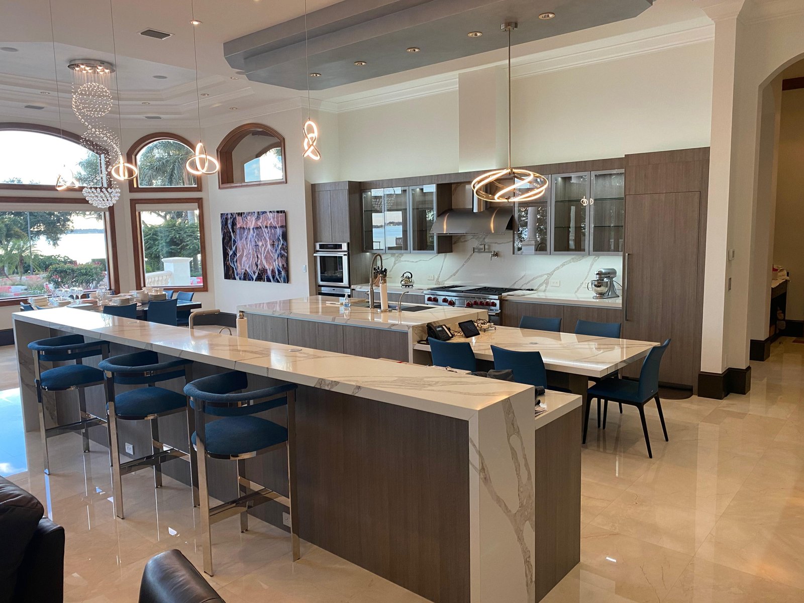 Open-concept kitchen integrating wood, glass, and quartz to achieve aesthetic uniformity.